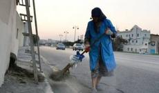 Bakıda qolu sarğılı qadın küçə süpürür